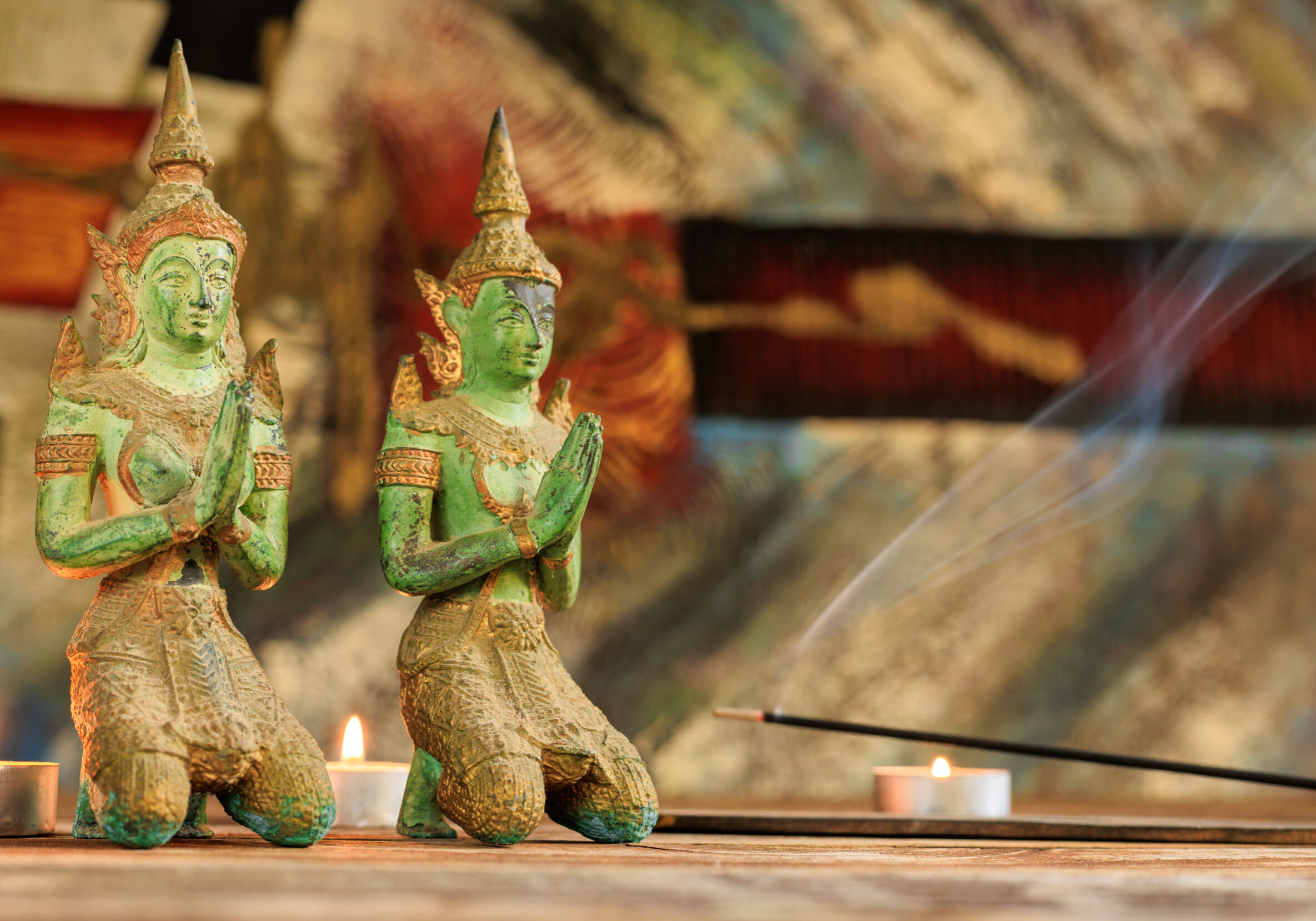 emeral green buddist statues with incesne and candles